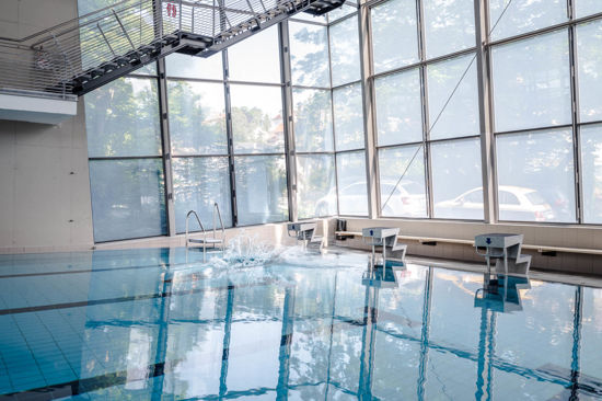 Sprung ins Schwimmbecken der Bodensee-Therme Überlingen mit großer Wasserfontäne im Innenbereich