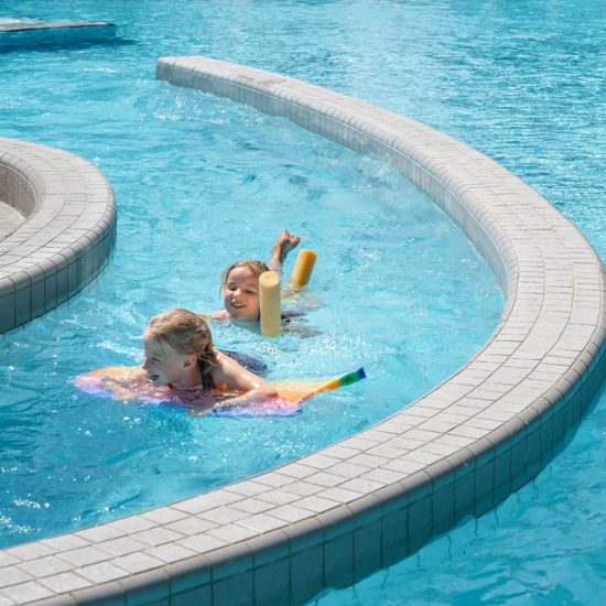 Zwei Kinder spielen mit Schwimmnudeln und Brett im Strömungskanal der Bodensee-Therme Überlingen